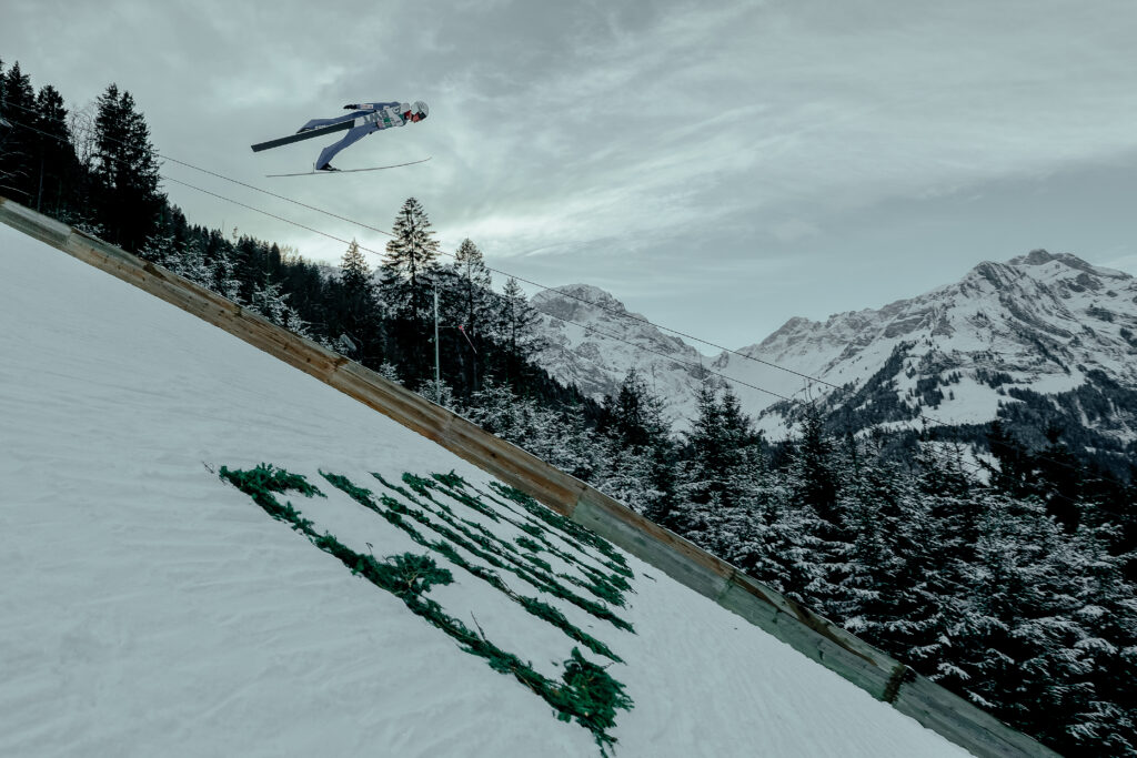 Skispringer fliegt über der Titlisschanze in Engelberg